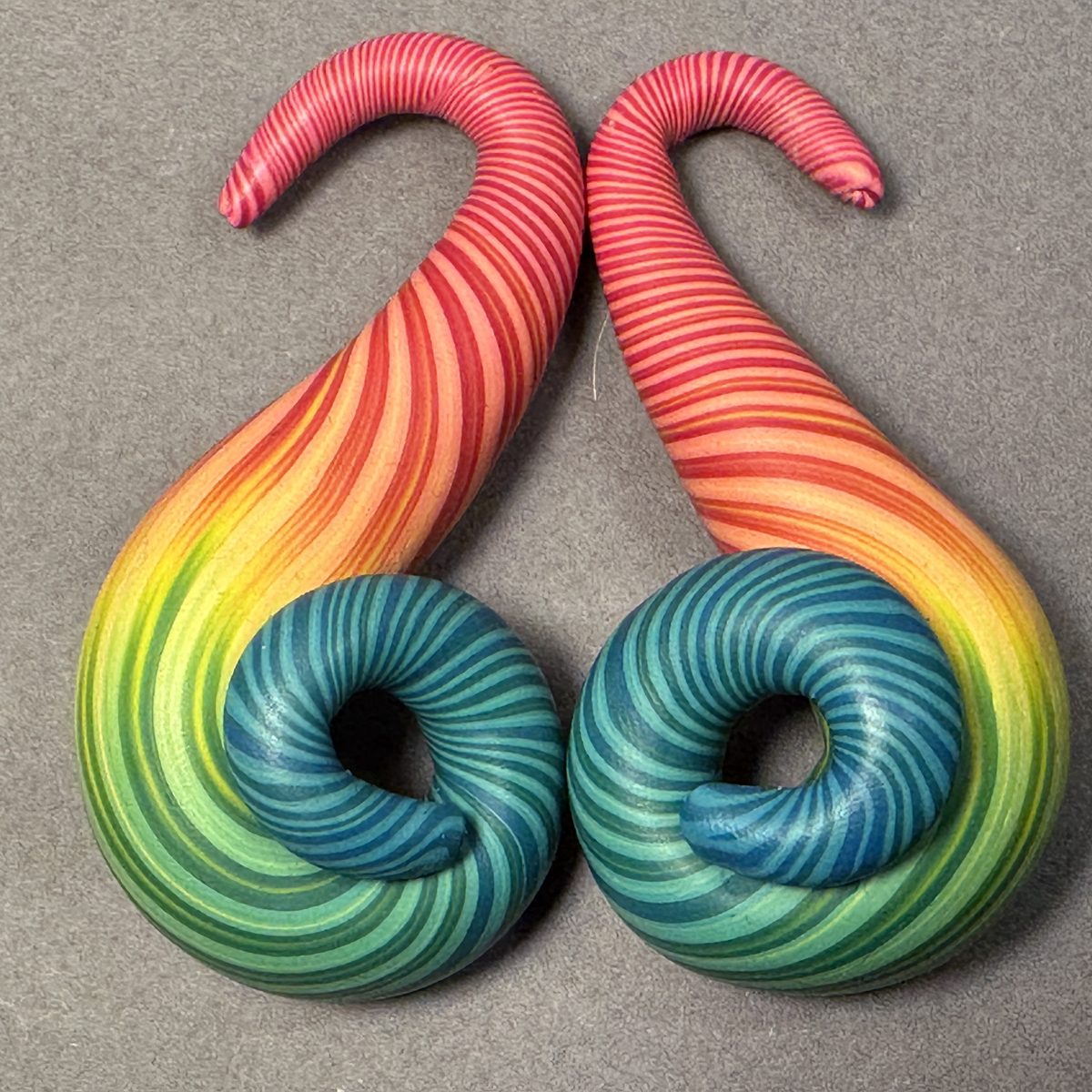 Rainbow spiral polymer clay gauge earrings, red fading down to blue and green curls